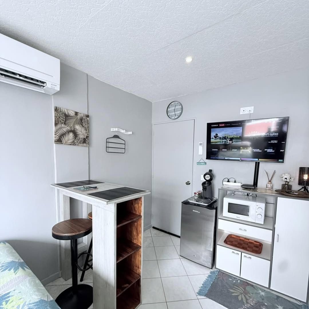 Bar haut avec tabourets, télévision et kitchenette